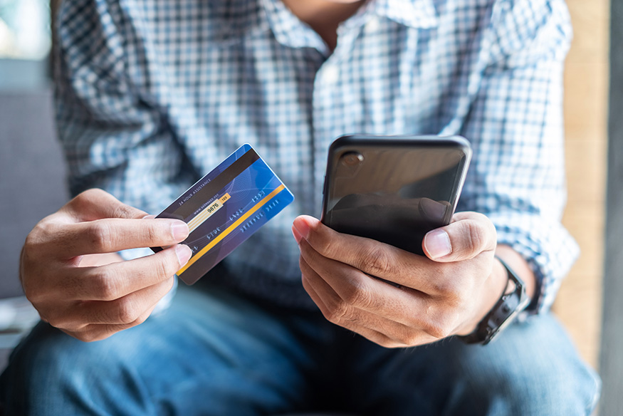 picture of man holding phone and credit card for mobile shopping